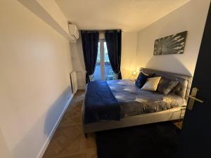 a bedroom with a bed with blue sheets and a window at Blue Haven Sèvres in Sèvres