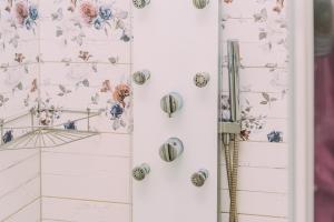 a room with a white wall with floral wallpaper at Éliás Borbirtok in Badacsonytomaj