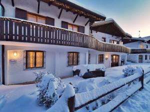 a house covered in snow with a fence at Casa Polsa 1964 in Brentonico