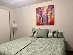 a bedroom with an elephant painting on the wall at Q80 Appartement in Schermbeck