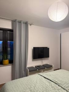 a bedroom with a bed and a flat screen tv at Q80 Appartement in Schermbeck