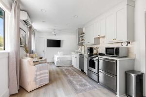 a kitchen with white cabinets and stainless steel appliances at The Sumter 1bd Condo 1 Block to Ocean in Folly Beach