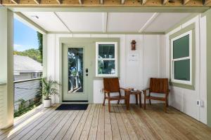 a screened porch with two chairs and a table at The Sumter 1bd Condo 1 Block to Ocean in Folly Beach +10 photos