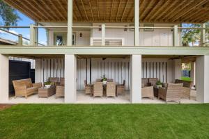 a patio with wicker chairs and tables on a lawn at The Sumter 1bd Condo 1 Block to Ocean in Folly Beach