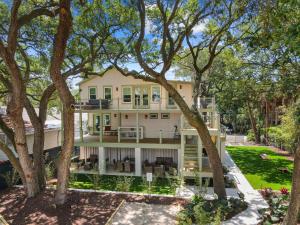 a large white house with trees in front of it at The Sumter 1bd Condo 1 Block to Ocean in Folly Beach