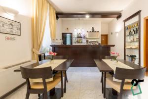 a dining room with two tables and a kitchen at Hotiday Cagliari Lungomare in Cagliari