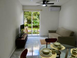 a living room with a couch and a table at NEW! Jungle Chic Retreat in Aldea Tulum in Tulum