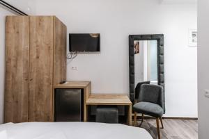 a bedroom with a bed and a desk and a tv at Ermou Residences in Volos