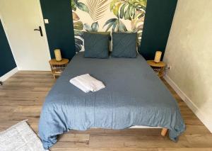 a bed with a blue blanket and pillows on it at La Chambre Bleue in Quimper