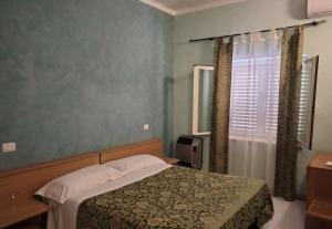 a bedroom with a bed and a window at Albergo Il Pescatore in Trevi