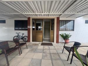 a patio with two chairs and a bike in front of a building at Apê aconchegante perto do mar in Cabedelo