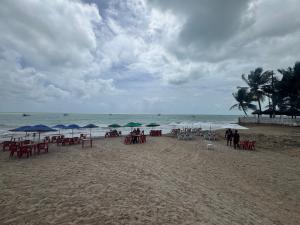 a beach with tables and umbrellas on the beach at Apê aconchegante perto do mar in Cabedelo