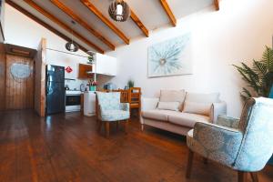 a living room with a couch and chairs and a kitchen at Algarrobo Cabaña a 2 cuadras Playa El Canelo+Wifi in Algarrobo