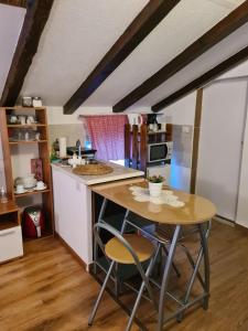 a kitchen with a table and some chairs in a room at Apartmani Viola in Momjan