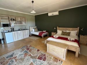 a bedroom with a large bed and a kitchen at Lake Grappa Guestfarm in Augrabies +76 photos
