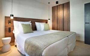 a bedroom with a large bed with white sheets and pillows at Hotel Coral Cotillo Reef in El Cotillo