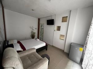 a living room with a bed and a couch at Hostal Casa Blanca in El Coca