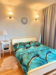a bedroom with a bed with a blue comforter at HomeComfort Atlantic Room in Warsaw