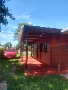 a small house with a car parked next to it at Cabaña Óga Pora' in Puerto Yeruá
