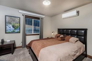 a bedroom with a large bed and a window at Pineview Cabin Retreat in the Black Hills- 4 bed, 2 bath in Sturgis