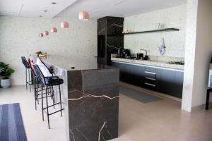 a kitchen with black counters and a counter top at Pousada Vista do Voo in Brumadinho