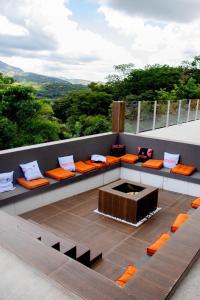 a patio with orange cushioned benches and a fire pit at Pousada Vista do Voo in Brumadinho