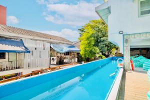 a pool at a hotel with blue water and chairs at Lazy Sunday Khaosan Hotel in Bangkok