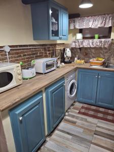 a kitchen with blue cabinets and a microwave at IL Vicoletto in Serra San Bruno +35 photos