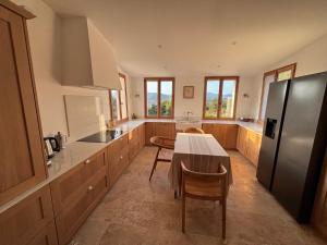 a kitchen with a table and a refrigerator at Maison Tropez in Cogolin