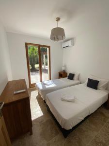 a bedroom with two beds and a table and a window at Maison Tropez in Cogolin