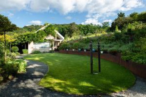 a garden with a fence and a house at Le B Cottage & SPA Privé in Riquewihr