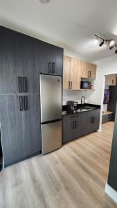 a kitchen with wooden cabinets and a stainless steel refrigerator at Pop Art Loft in Hialeah