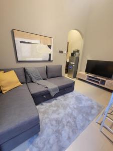 a living room with a couch and a flat screen tv at Cozy, Tiny, Retreat Studio in a prime location in Abu Dhabi