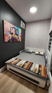 a bedroom with a bed with a painting on the wall at Pop Art Loft in Hialeah