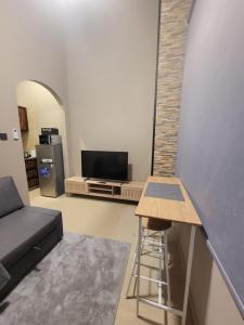 a living room with a couch and a bar stool at Cozy, Tiny, Retreat Studio in a prime location in Abu Dhabi +5 photos