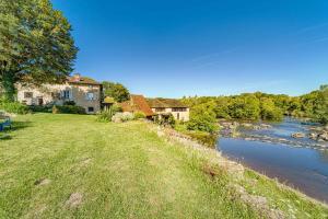 a house on the side of a river at Couleurs du Daumail in Saint-Priest-sous-Aixe