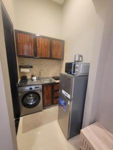 a small kitchen with a stainless steel refrigerator and a sink at Cozy, Tiny, Retreat Studio in a prime location in Abu Dhabi