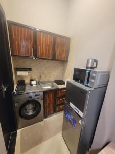 a small kitchen with a sink and a refrigerator at Cozy, Tiny, Retreat Studio in a prime location in Abu Dhabi