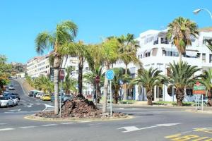 a street with palm trees in the middle of the road at FN Funchal Tenerife in Los Cristianos