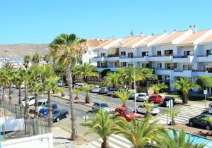 a parking lot with cars parked in front of a building at FN Funchal Tenerife in Los Cristianos
