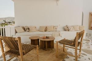 a living room with a couch and a table and chairs at Maria's place boutique hotel in Antiparos