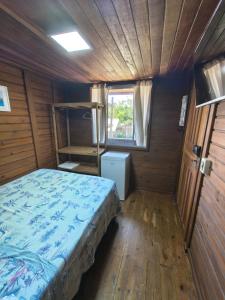 a bedroom with a bed in a wooden room at Oka do Mar Hospedaria - Suíte com varanda na Ilha do Mel - Nova Brasília in Ilha do Mel