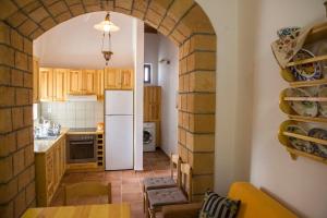 a kitchen with an archway with a white refrigerator at Traditional Stay in Archangelos +13 photos
