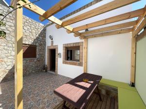 a patio with a wooden table and a wooden pergola at Traditional Stay in Archangelos