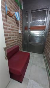 a red couch in a room with a door at Departamento familiar in General Roca