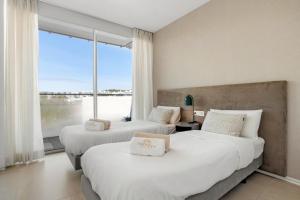 two beds in a hotel room with a large window at Casa Costa Tropical in Estepona +25 photos