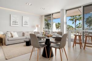 a dining room and living room with a table and chairs at Casa Costa Tropical in Estepona