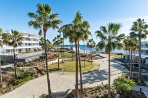 a view of a park with palm trees and the ocean at Casa Costa Tropical in Estepona