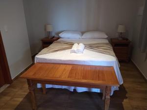 a bed with a wooden table in a room at pousada mar e vento in Touros