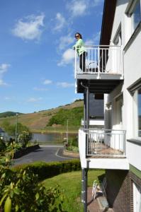 a woman standing on the balcony of a building at Weingut im Moselkrampen in Ellenz-Poltersdorf